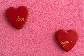 Two heart shaped cookies on pink background. Copy space. Love you. Valentines Day.