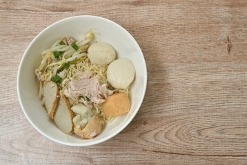 dry egg yellow noodles  noodles topping slice boiled pork and ball on bowl