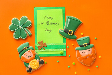 Composition with tasty gingerbread cookies for St. Patrick's Day celebration on orange background