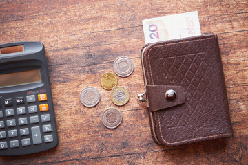 monety ,banknot i kalkulator na drewnianym stol ,polski złoty 