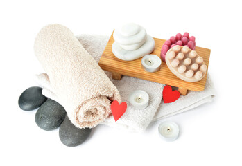 Obraz na płótnie Canvas Wooden board with massage brushes, spa stones, towel and burning candles isolated on white background. Valentine's Day celebration