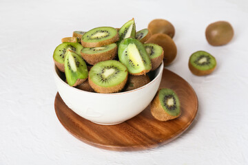 Bowl with fresh cut kiwi on light background, closeup