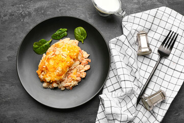 Plate with tasty English fish pie on black background