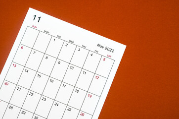 November 2022 calendar sheet on red background.