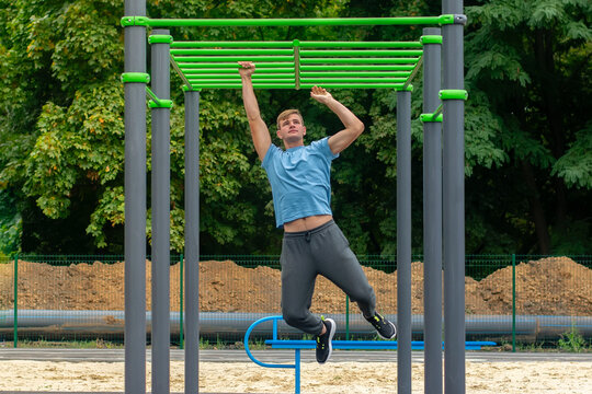 A male athlete trains on a horizontal bar.