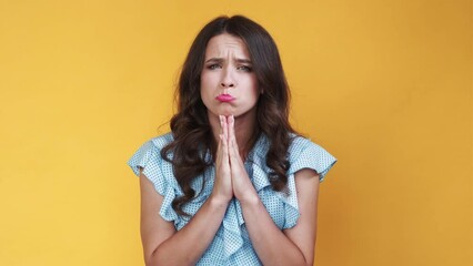 Begging face. Meme woman. Sorry feelings. Sulking pouting lady holding hands asking apologise isolated orange looped video.