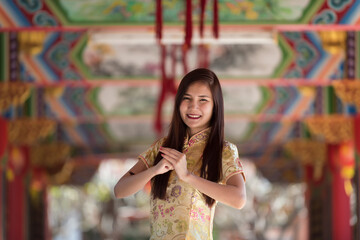Beautiful Asian woman with congratulate gesture in Chinese New Year.