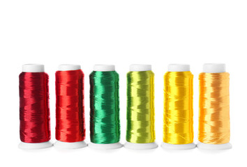 Different sewing thread spools on white background