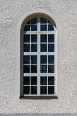 Fototapeta na wymiar Large vaulted window on a white wall