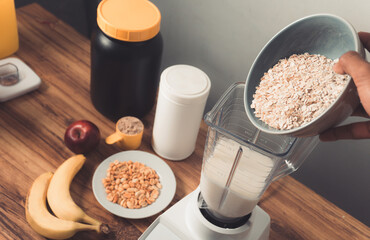 Pov preparing a protein shake with oatmeal,banana and peanut.