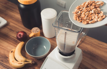 preparation of a protein smoothie by adding a cup of roasted peanuts
