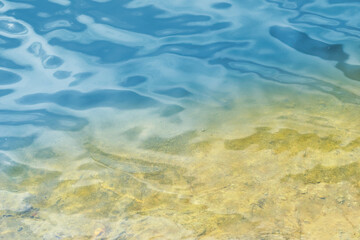 Fototapeta na wymiar Sandy bottom under blue water. Natural background