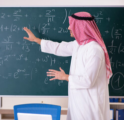 The arab teacher in front of chalkboard