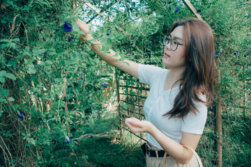 Beautiful Asian woman wearing glasses and a white shirt holding a wicker basket standing in the...