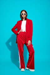 Fashion asian female model in red suit, white boots and sunglasses.