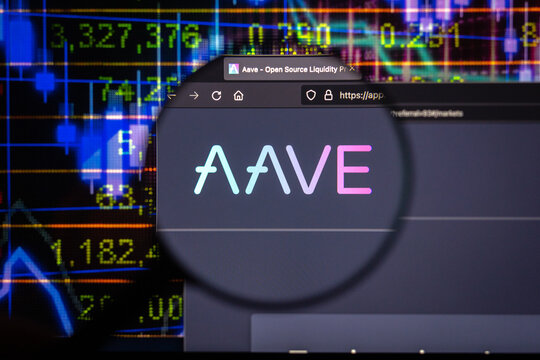 Aave crypto company logo on a website, seen on a computer screen through a magnifying glass.	