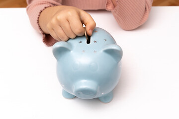 Obraz na płótnie Canvas Cute little girl with piggy bank at home. Adorable child with moneybox. Lifestyle and real people concept. Children's pocket money. Savings, budget planning starts from childhood.