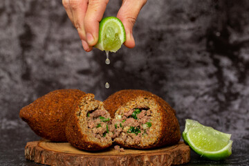 The traditional Arabic snack of kibbeh in Brazil called Quibe. Kibe served with lemon