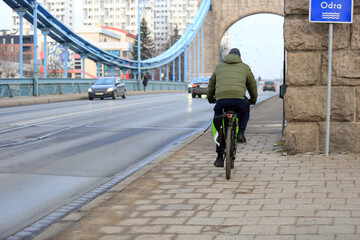 Mężczyzna jedzie  na rowerze po moście Grunwaldzkim we Wrocławiu.  © Stanisław Błachowicz
