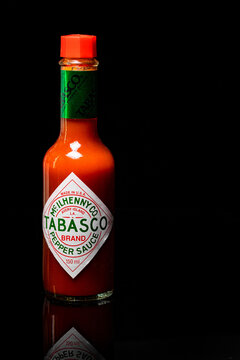 Cape Town, South Africa - January 19, 2022: Small bottle of Tabasco chilli sauce on a black reflective surface