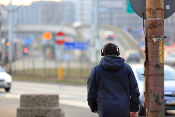 Mężczyzna ze słuchawkami na głowie spaceruje mostem Grunwaldzkim nad Odrą we Wrocławiu. - obrazy, fototapety, plakaty