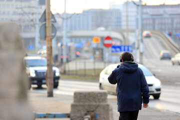 Mężczyzna ze słuchawkami na głowie spaceruje mostem Grunwaldzkim nad Odrą we Wrocławiu. - obrazy, fototapety, plakaty