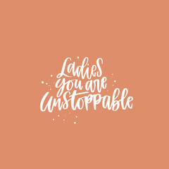 Positive inspirational quote hand drawn color vector lettering Ladies you are unstoppable. Abstract drawing with text isolated on orange background.