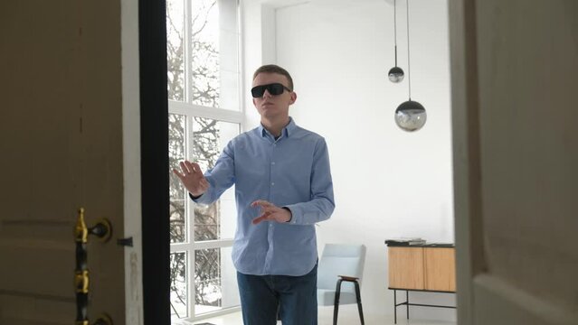 Blind man cautiously moving towards the exit in the apartment