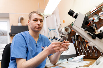 Handsome man making eyeglasses lenses. Ophtalmologist consultant working with glasses.