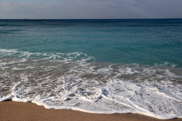 Fototapeta na wymiar Clear blue sea water close up photo. Calm sea, blue sky, tranquil scene. Warm day on the beach. 