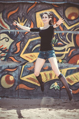 Fototapeta na wymiar a young girl on the background of graffiti