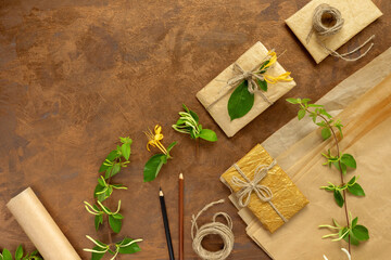 Gifts in paper wrapping, set of vintage yellow package paper, rolls, ropes and pencils for...