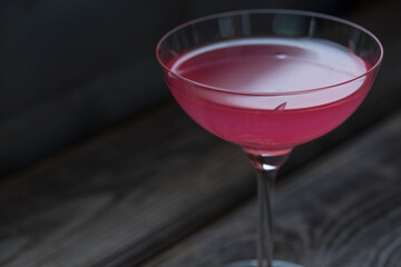Dark key. Selective focus. Delicious pink refreshing rose drink, wooden background. scandinavian style. cocktail. copy space.