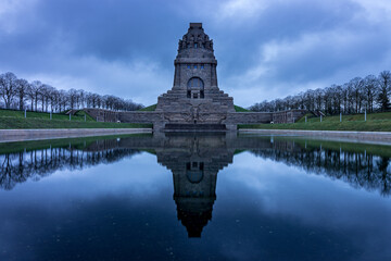 Monument to the Battle of the Nations at sunrise with a lake in the foreground