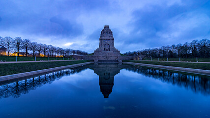 Monument to the Battle of the Nations at sunrise with a lake in the foreground