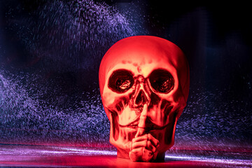 Rot angeleuchteter Totenkopf im dunklen Hintergrund mit Lichtspuren