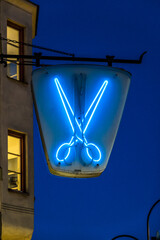 Stockholm, Sweden A scissors sign at night above a hairdresser/barber shop on Hagerstensvagen.
