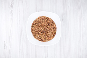 buckwheat in a white plate on the table. buckwheat in the kitchen