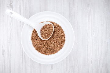 buckwheat in a white bowl with a spoon on the table