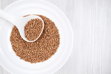 buckwheat in a white bowl with a spoon on the table