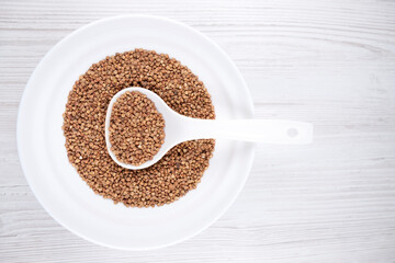 buckwheat in a white bowl with a spoon on the table