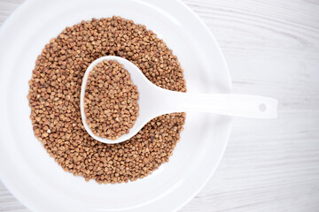 buckwheat in a white bowl with a spoon on the table