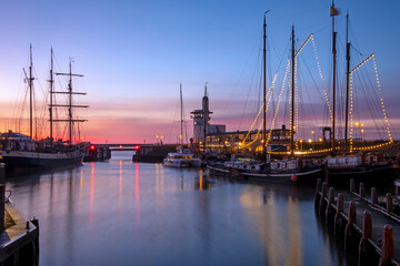 Fototapeta na wymiar Harbor from Harlingen with decorated sailing boats in Friesland the Netherlands at sunset