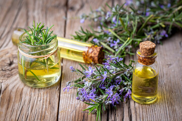 Rosemary herbal essential oil on the wooden background