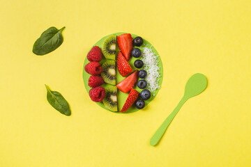 smoothie bowl with fresh berries and fruits in paper craft plate on yellow