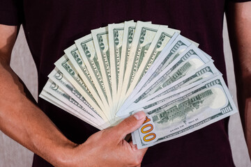 dollars are held by fan by a man in his hand. Us dollar.