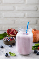 Vegan protein smoothie made from pomegranate and blueberry on a stone tabletop. Healthy food. Lifestyle wellness. Foodism, rawism, raw food diet. Copy space.