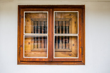 Old square wooden window with protective decorations. Bulgaria