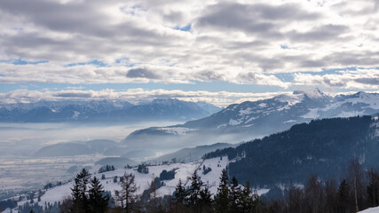 Fototapeta na wymiar Winterlandschaft mit Nebel, Bergen, Alpen und Täler