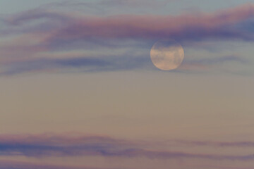 Morgenstimmung mit Mond hinter den rosa Wolken.